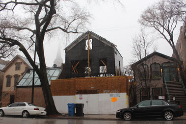  With the steeple of St. Michael's Roman Catholic Church in the background, the building at 1720 N. Sedgwick Ave. stands in the rain Thursday with no roof , no tarp and open walls. 